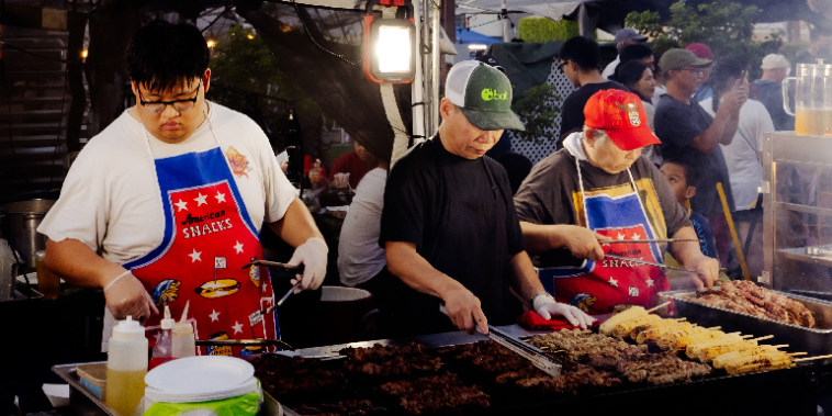 Chefs prepare food at the Little Saigon Night Market at the Asian Garden Mall