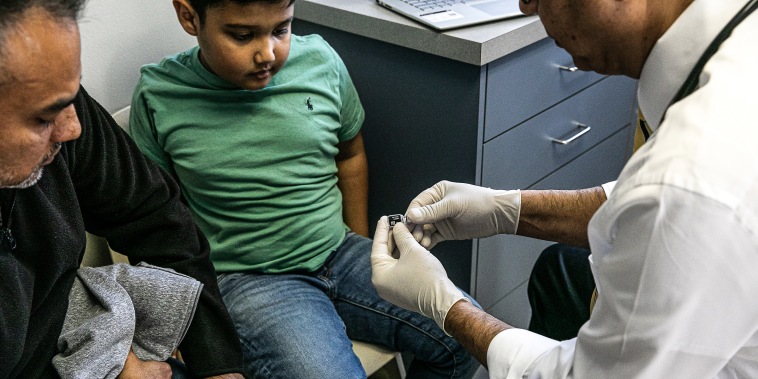 Pediatrician shows the Covid vaccine to a 7-year-old